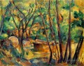 Mühlstein und Zisterne unter Bäumen Paul Cezanne
